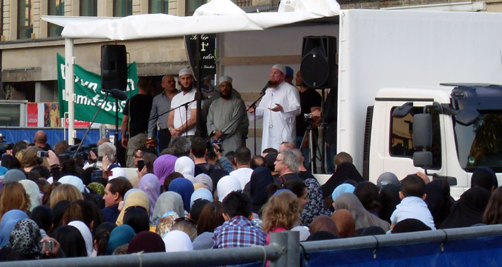 Bilal Philips (M., in grau) und Pierre Vogel (r., in weiß) als Redner vor Anhängern bei einer Kundgebung in Frankfurt am Main 2011