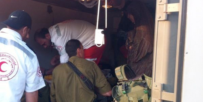 Israelische Streitkräfte und palästinensische Rettungssanitäter helfen gemeinsam einem Baby.