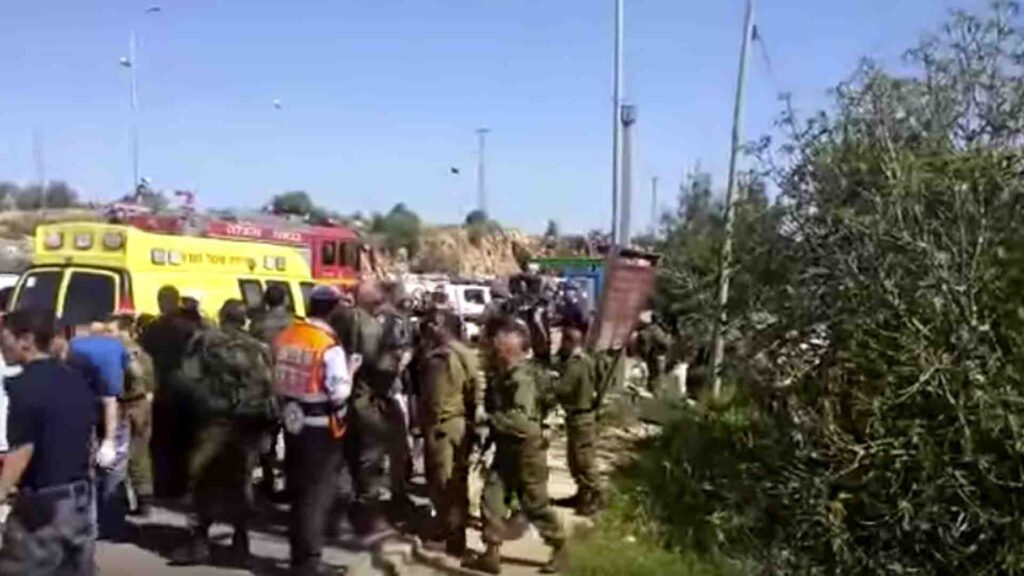 Rettungskräfte und Soldaten am Ort des Anschlags, einer mit Pollern und Betonklötzen gesicherten Bushaltestelle bei der Siedlung Ofra